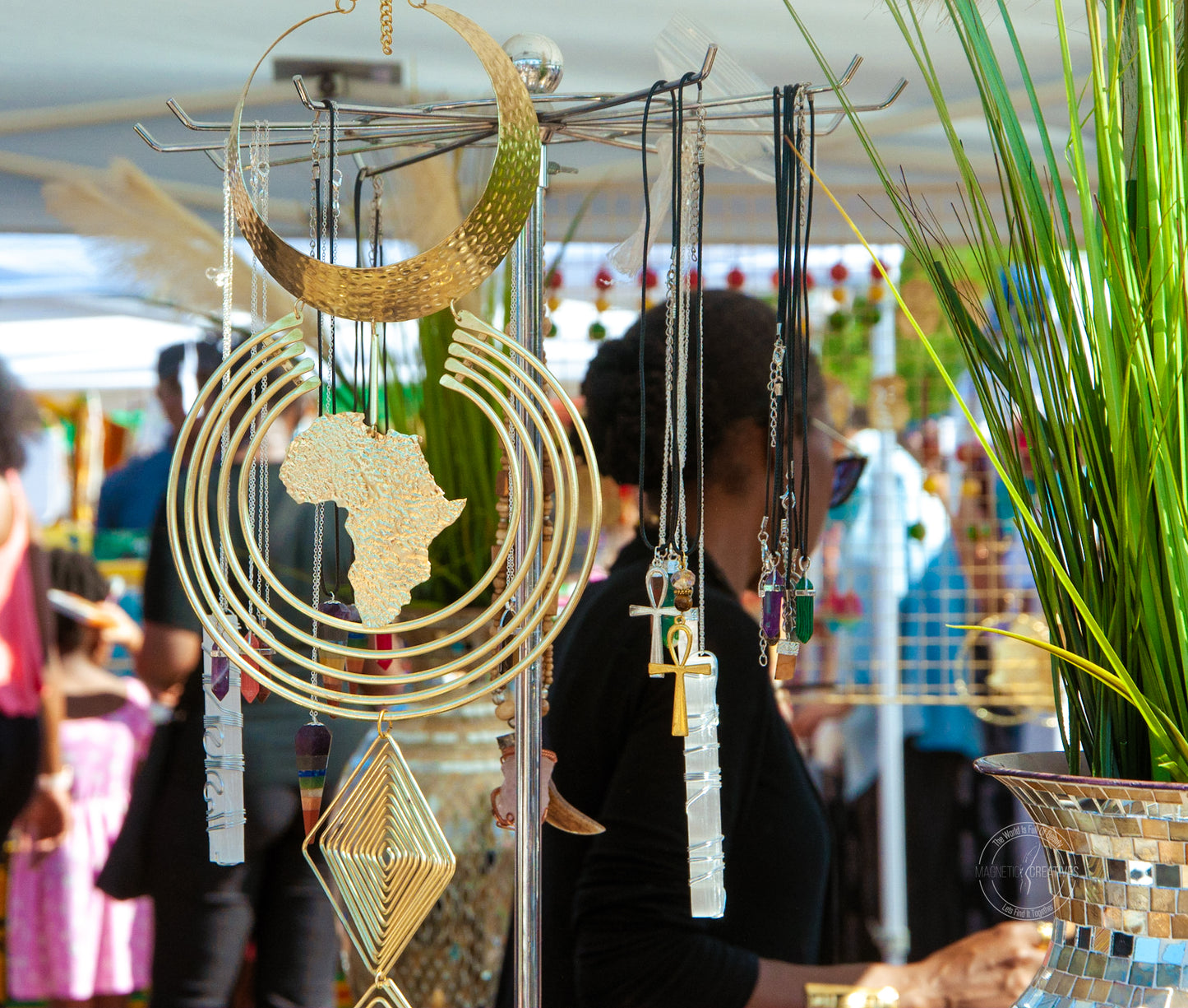 African gold jewelry, necklaces with the Ankh, the afrikan continent. There is a green plant in the right side of the photo